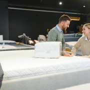 Happy couple choosing furniture in store.