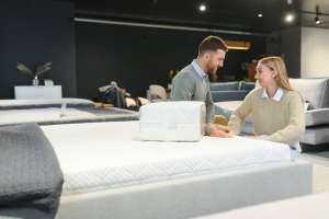 Happy couple choosing furniture in store.